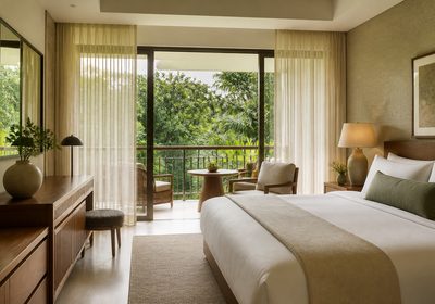 A garden king room with linen curtains and a balcony